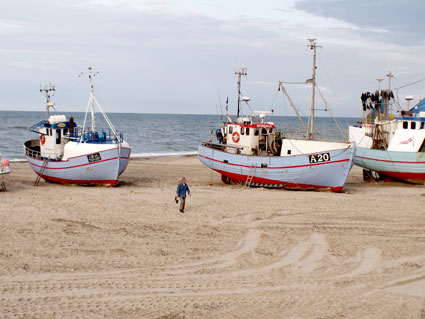 Kurt Mortensen ser på fiskekuttere trukket op på stranden i Torup.